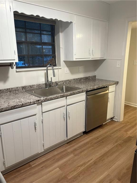 Kitchen featuring light wood-type flooring, white cabinets, and dishwasher