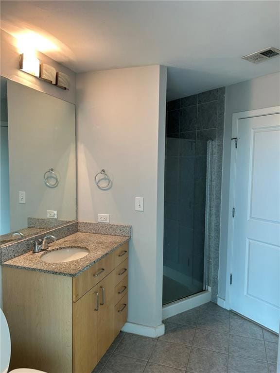 Full bath with vanity, a shower stall, tile patterned floors, and toilet