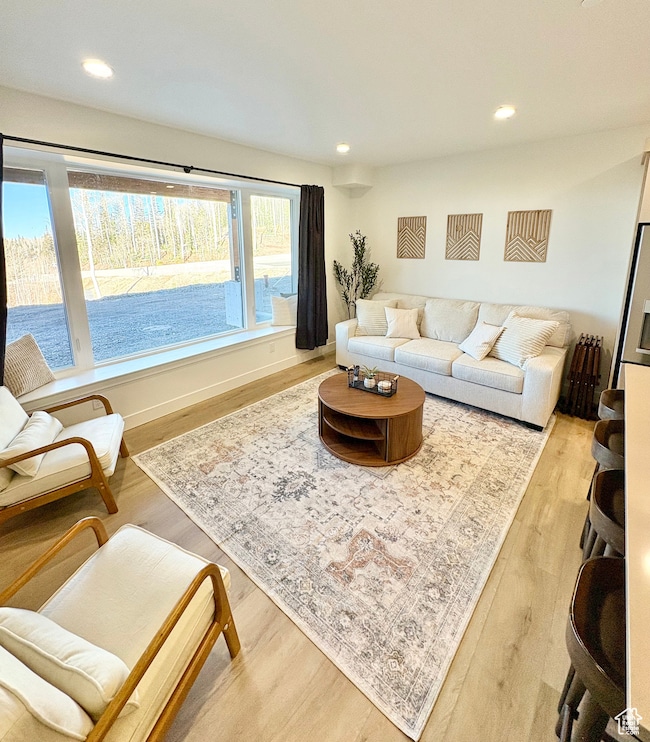 Living room with light wood finished floors and recessed lighting