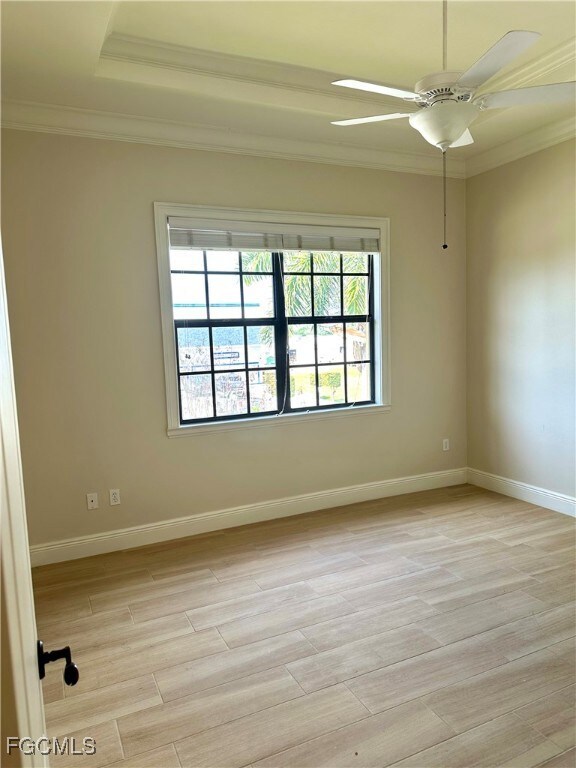 Unfurnished guest bedroom with crown molding, light wood tile floors, and ceiling fan