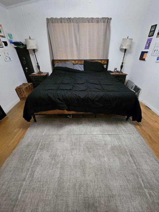 Bedroom featuring baseboards and light wood-type 