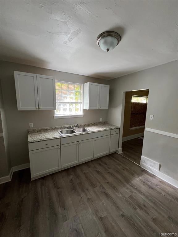 Kitchen featuring light countertops, white cabinets, and dark wood-type flooring