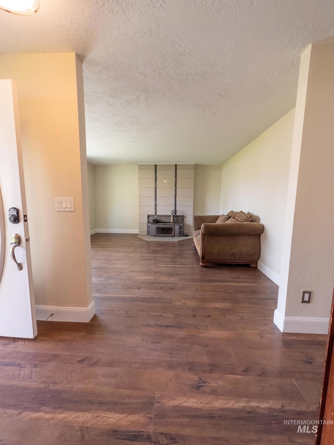 Living room with dark wood-style flooring and a textured ceiling