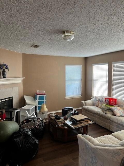 Living room featuring a tile fireplace, dark hardw