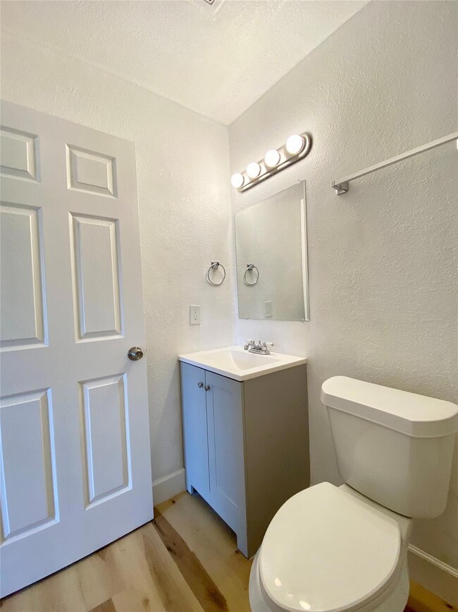Half bath featuring light wood finished floors, a