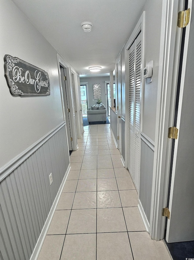 Corridor featuring light tile patterned floors and