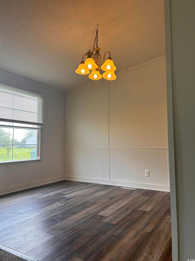 Empty room featuring an inviting chandelier, a tex