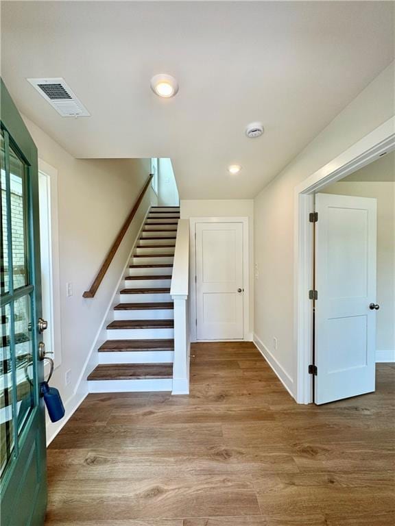 Foyer entrance featuring wood finished floors, stairway, baseboards, and recessed lighting