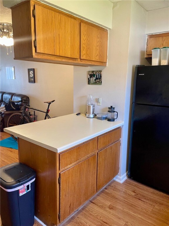 Kitchen with freestanding refrigerator, a peninsul
