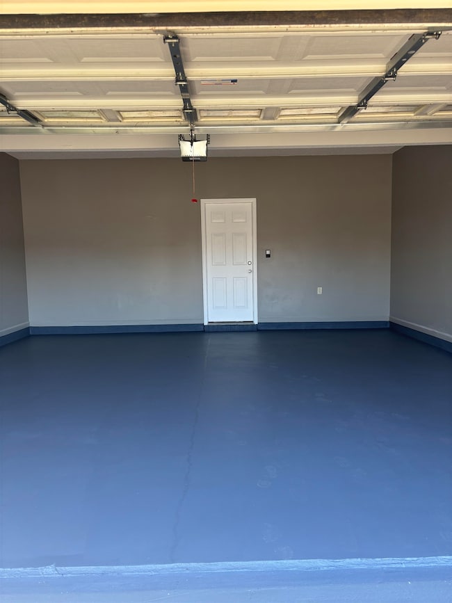 Garage with a garage door opener and baseboards