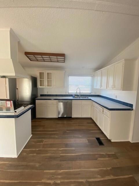 Kitchen featuring white cabinetry, range, extractor fan, and a textured ceiling