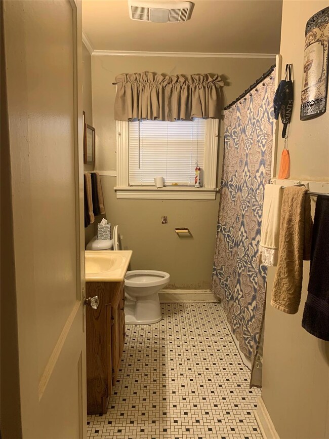 Bathroom with tile floors, ornamental molding, toi