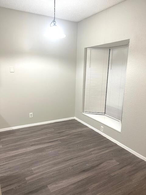 Unfurnished room with dark wood-style flooring, b