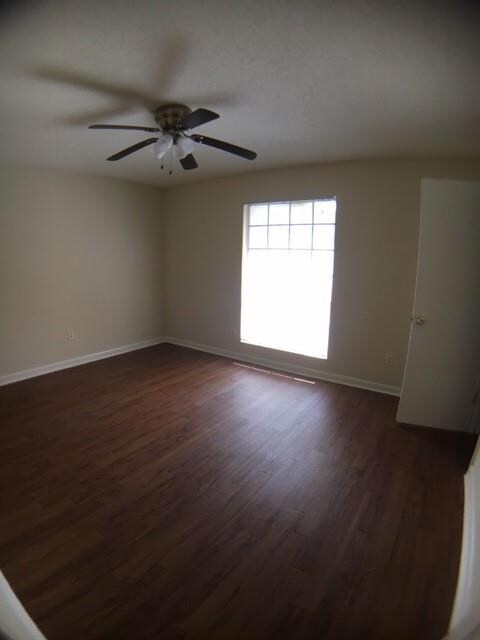 Empty room featuring dark wood-style floors, ceil