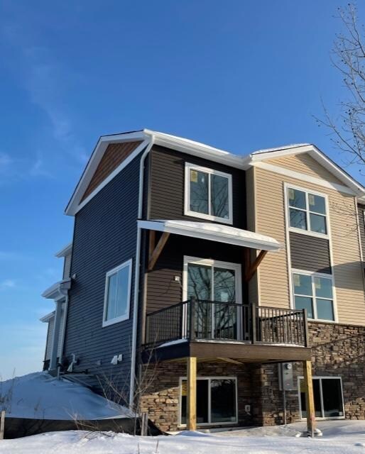 Back of the home features stone accents, maintenance free deck and rails, and a decorative roof apron.