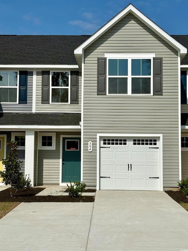 Townhome / multi-family property with driveway, a 