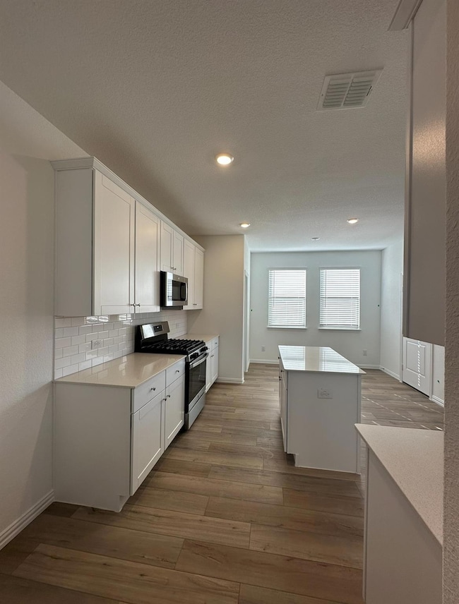Kitchen with visible vents, wood finished floors, 