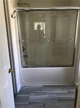 Full bathroom featuring shower / bath combination with glass door