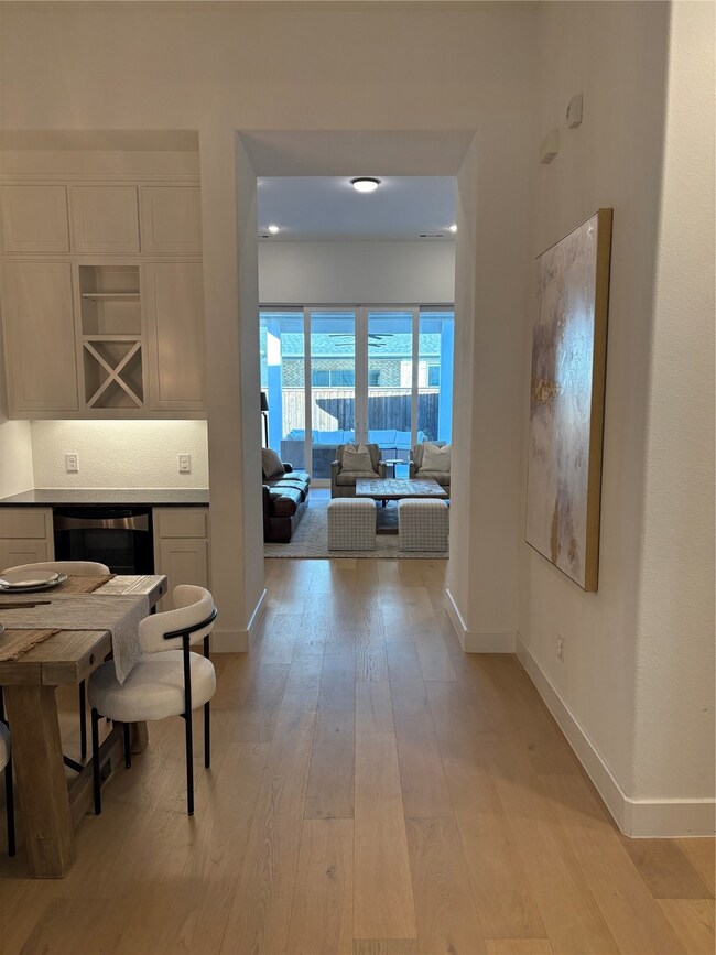 Corridor with light wood-style flooring and beverage cooler