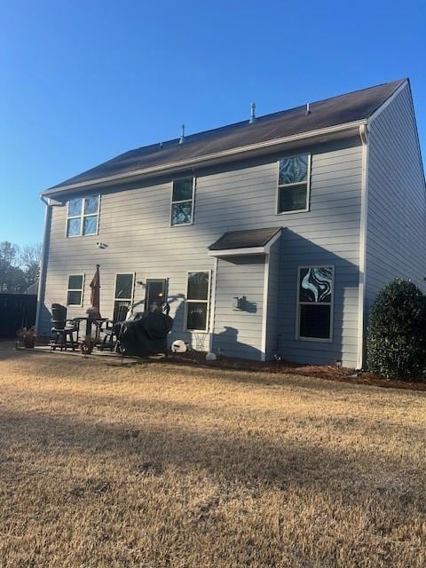 Rear view of house featuring a lawn