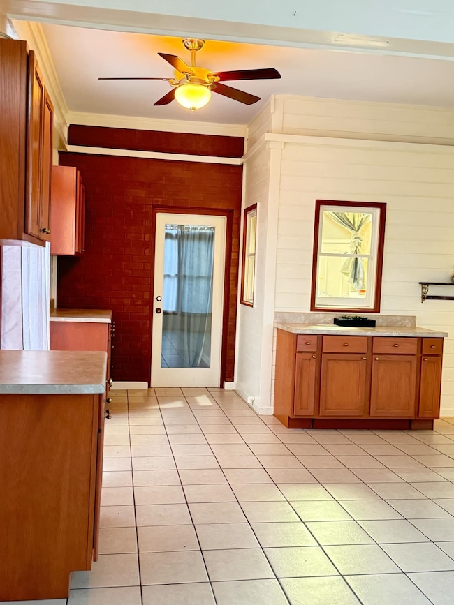 Kitchen with brown cabinetry, light tile patterned