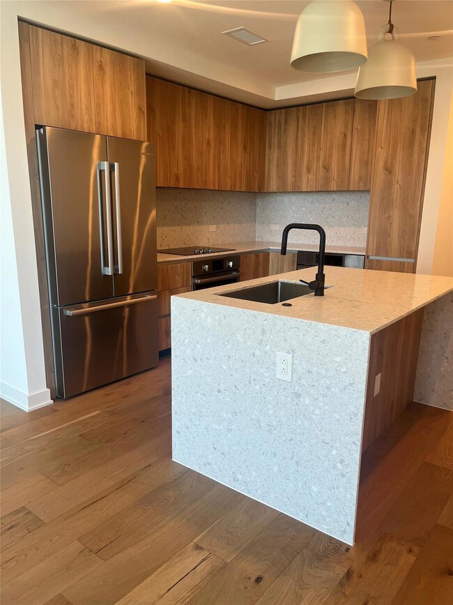 Kitchen featuring high quality fridge, brown cabi