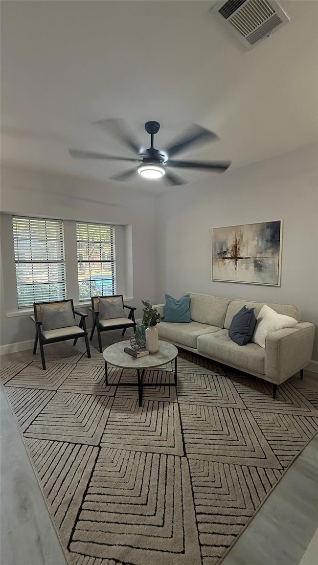 Living room featuring ceiling fan and wood finished floors
