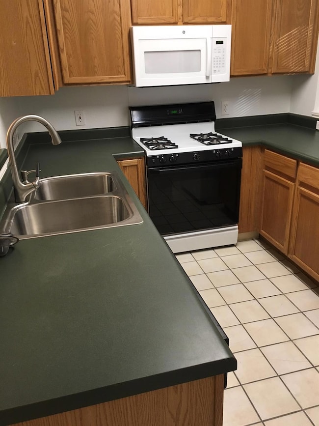Kitchen featuring dark countertops, white microwa