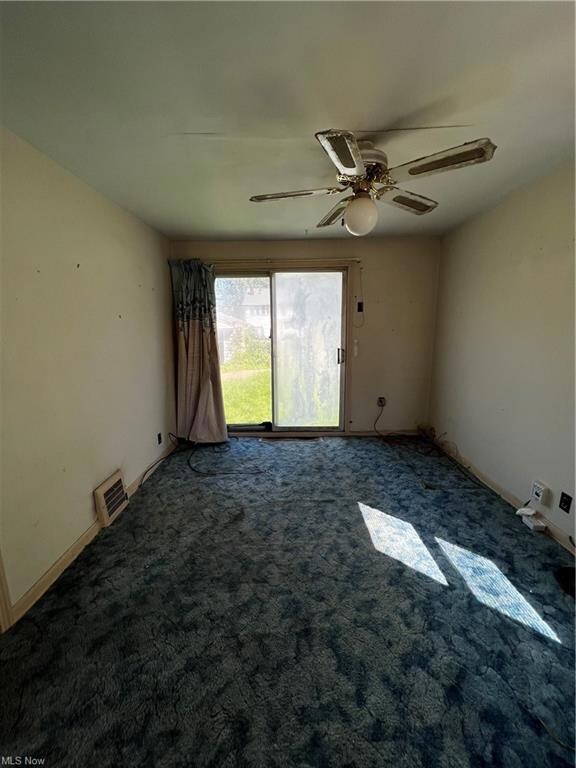 Unfurnished room featuring carpet and ceiling fan