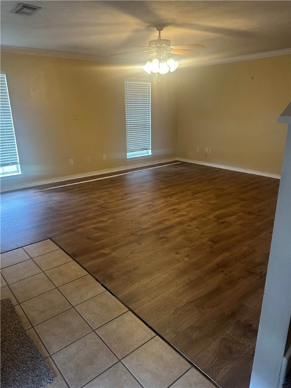 Spare room featuring ornamental molding, wood fini