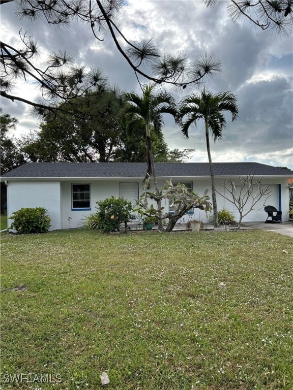 View of side of home featuring a garage and a yard