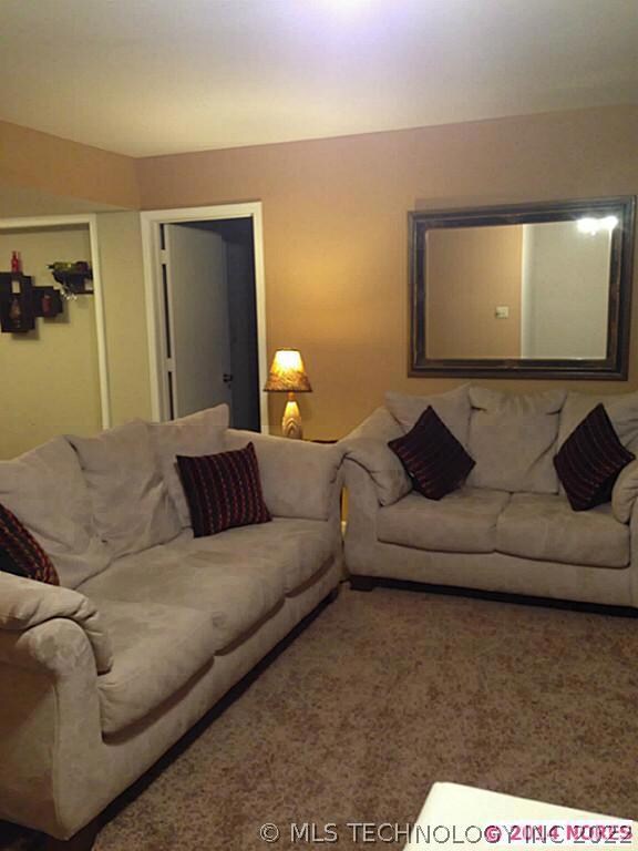 View of living room with couch and love seat.