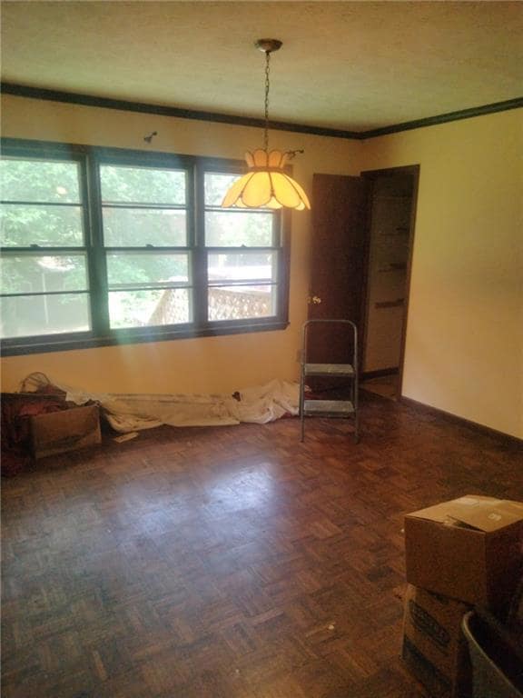Spare room featuring healthy amount of natural light and crown molding