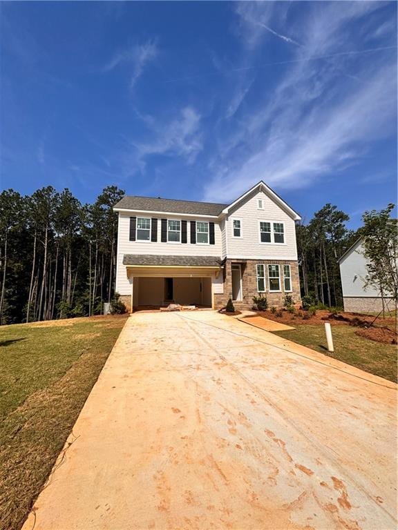 View of front of home with driveway, a front lawn, and an attached garage