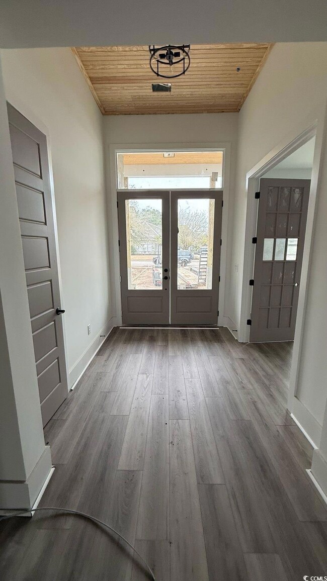 Foyer featuring french doors, wood ceiling, basebo
