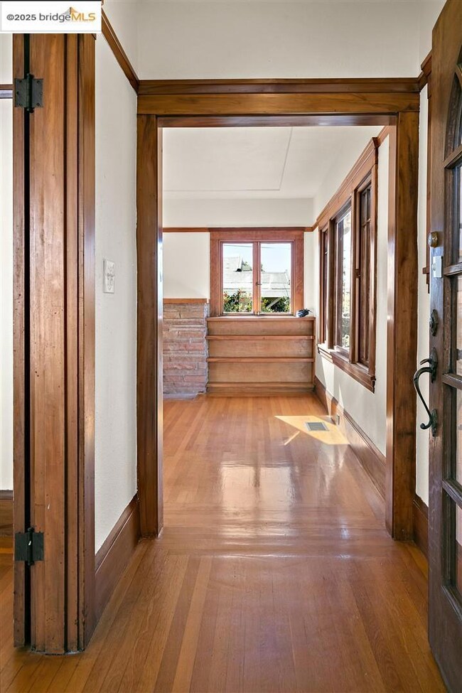 Hallway with wood-type flooring and baseboards