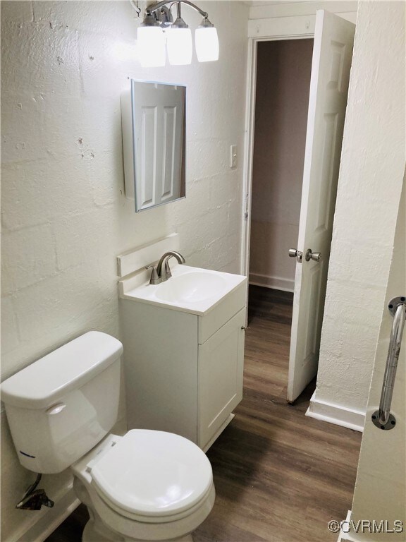 Half bathroom with toilet, wood finished floors, v