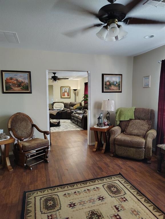 Living room with ceiling fan and wood-type floorin