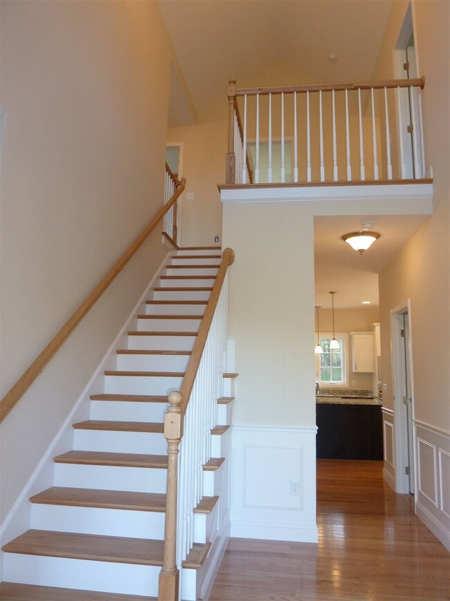 Foyer with vaulted ceiling, hardwood floors and ba
