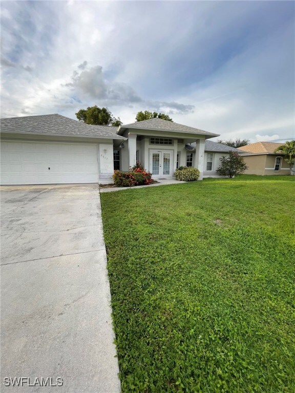 View of front facade with a garage and a front law