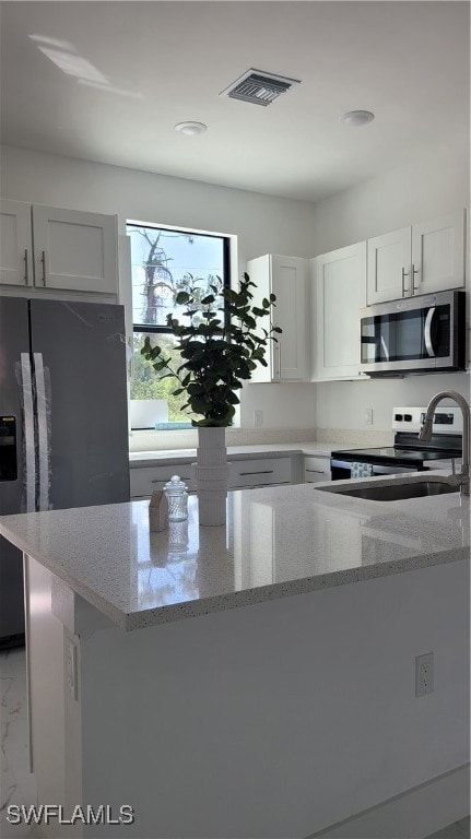 Kitchen featuring refrigerator, light stone counte