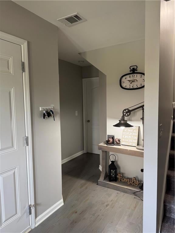 Stairway with wood finished floors and baseboards