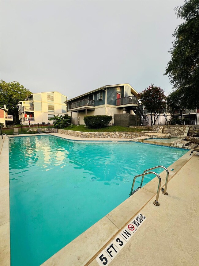Community pool with stairway and a hot tub
