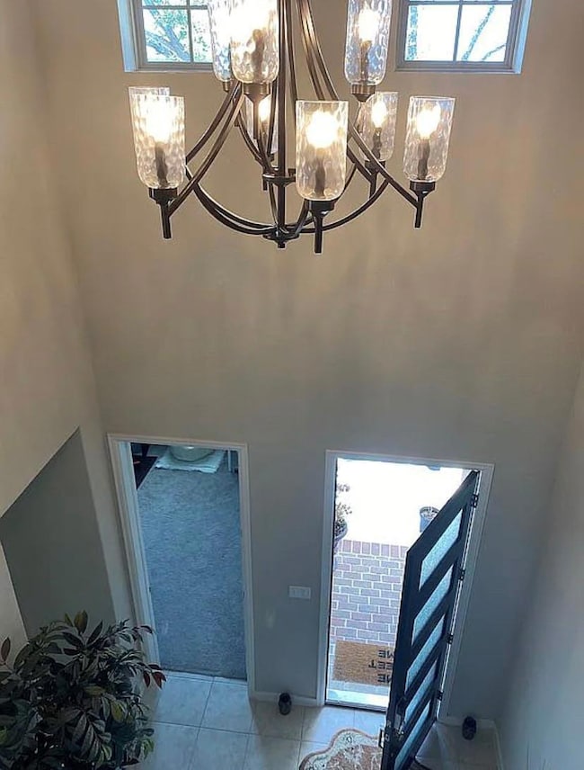 Foyer entrance with a chandelier, a towering ceil
