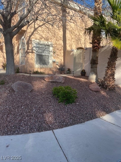 View of property exterior with a gate and stucco s