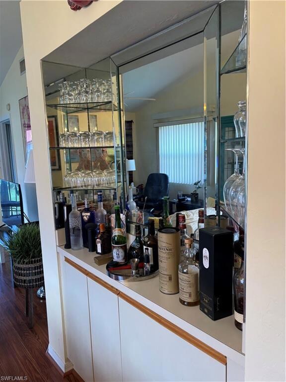 Bar area with vaulted ceiling and wood finished fl