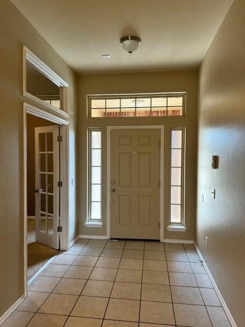 Entrance foyer featuring light tile patterned floors and baseboards