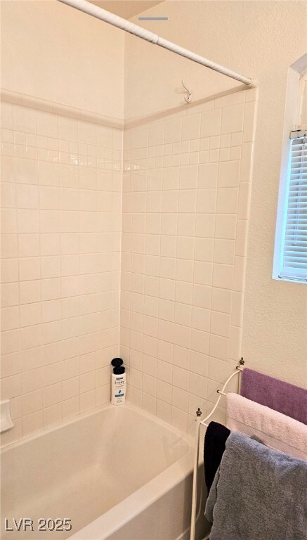 Bathroom with shower / bath combination and a text