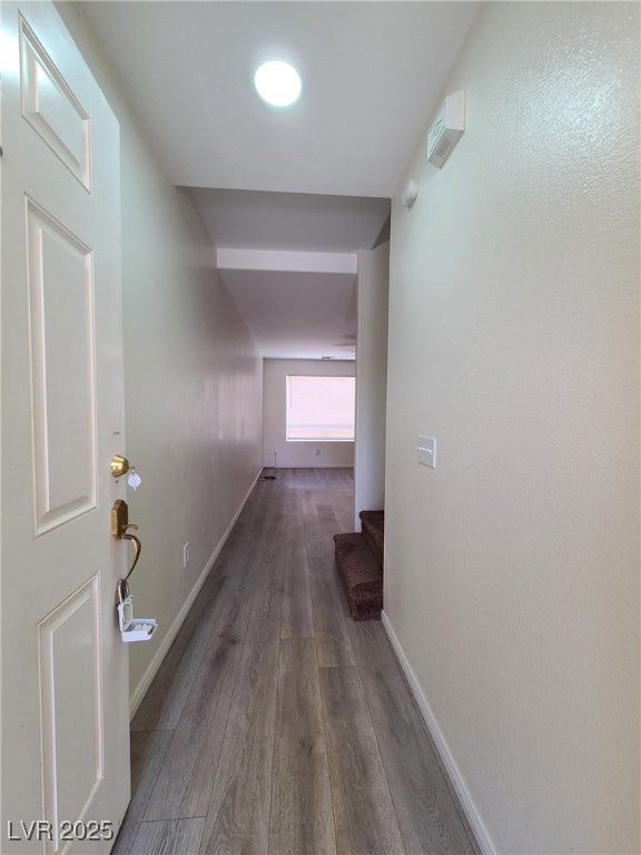 Corridor featuring wood finished floors and basebo