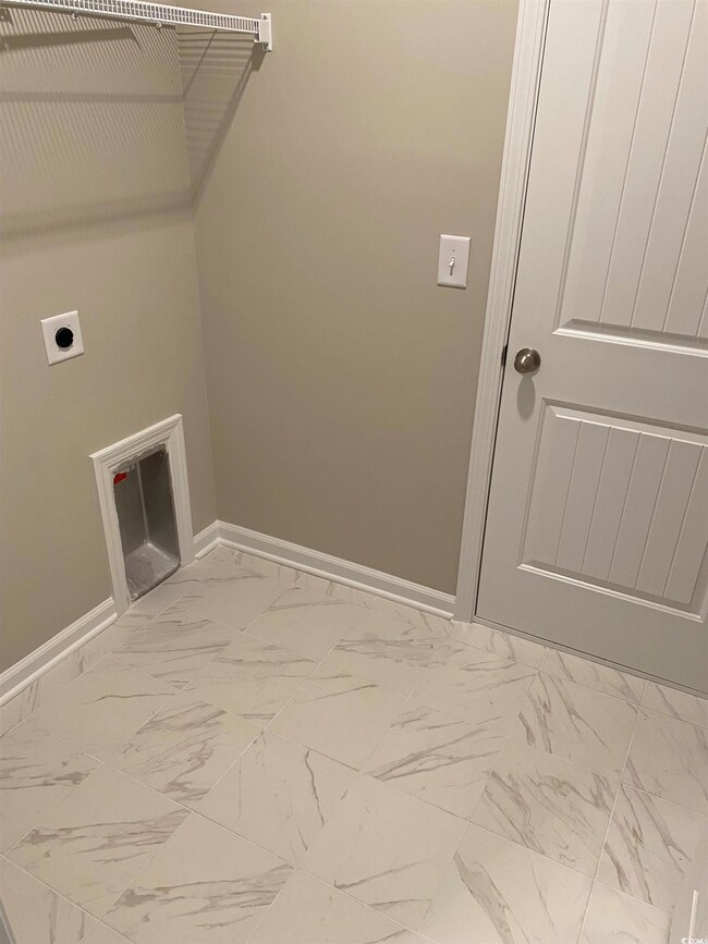 Laundry room with tile patterned floors and electr